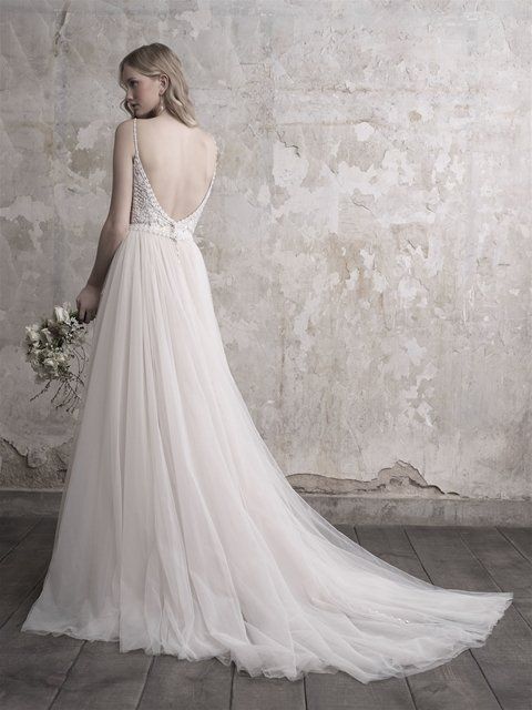 Eine Frau trägt ein weißes Brautkleid und hält einen Blumenstrauß.