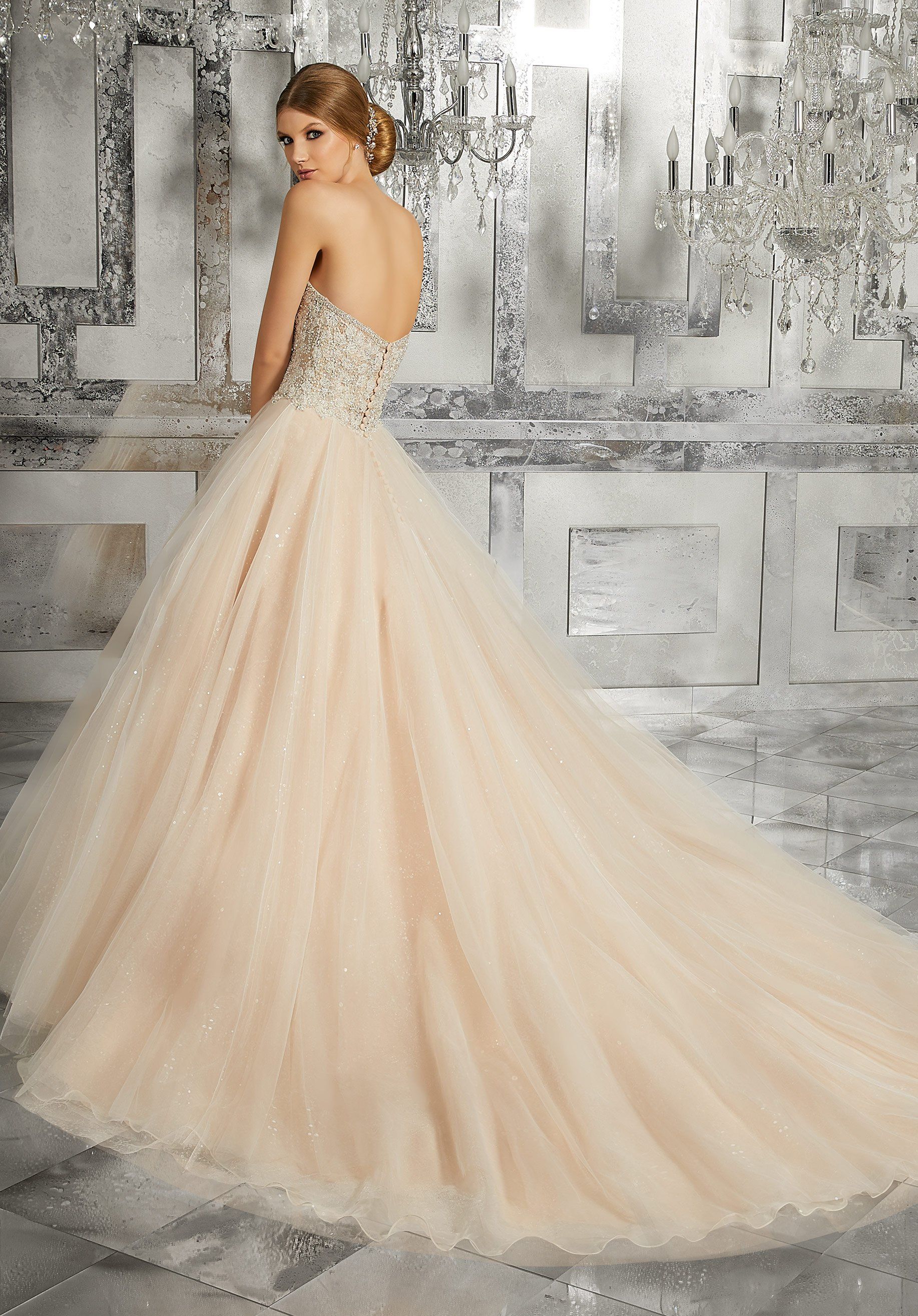 Eine Frau in einem Ballkleid steht vor einer Wand.