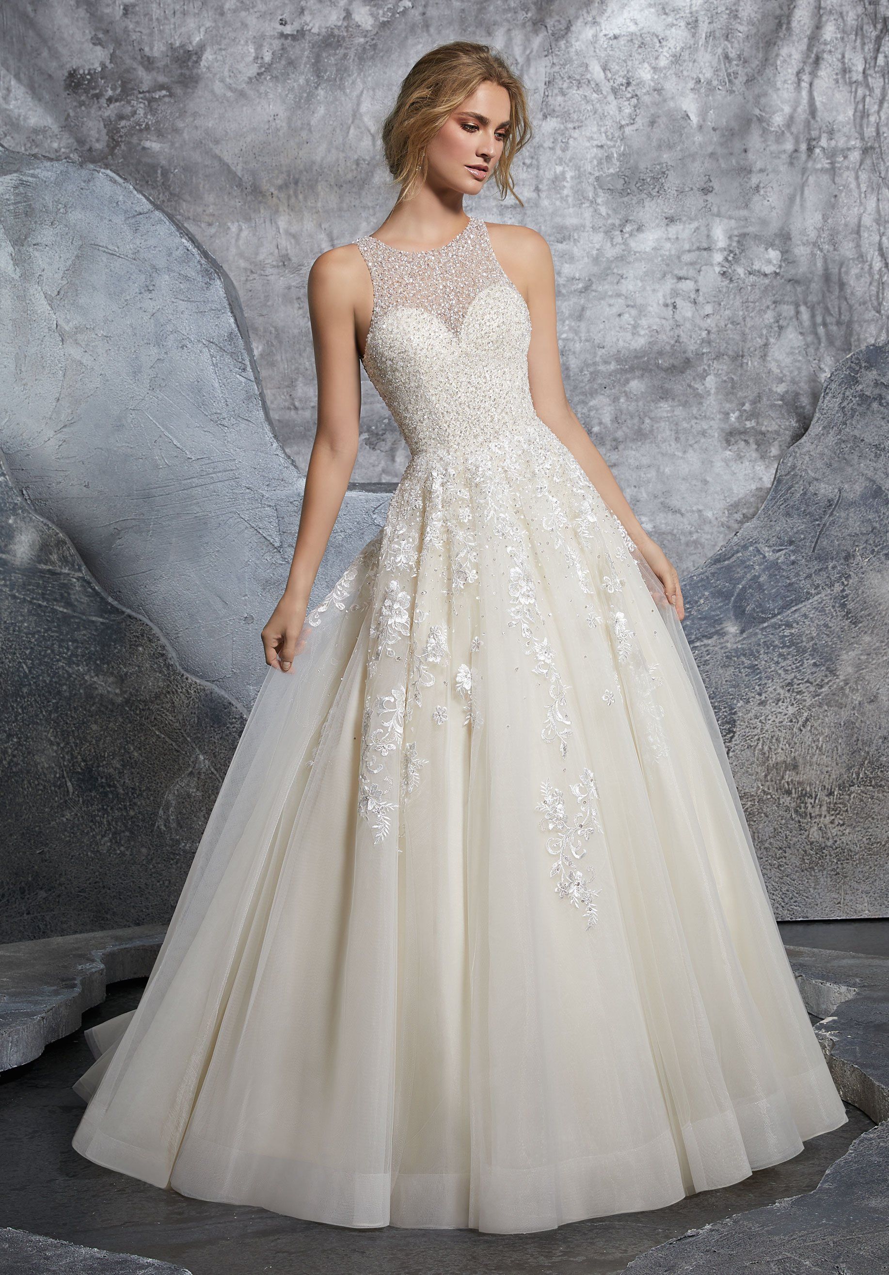 Eine Frau in einem weißen Brautkleid steht vor einem Felsen.