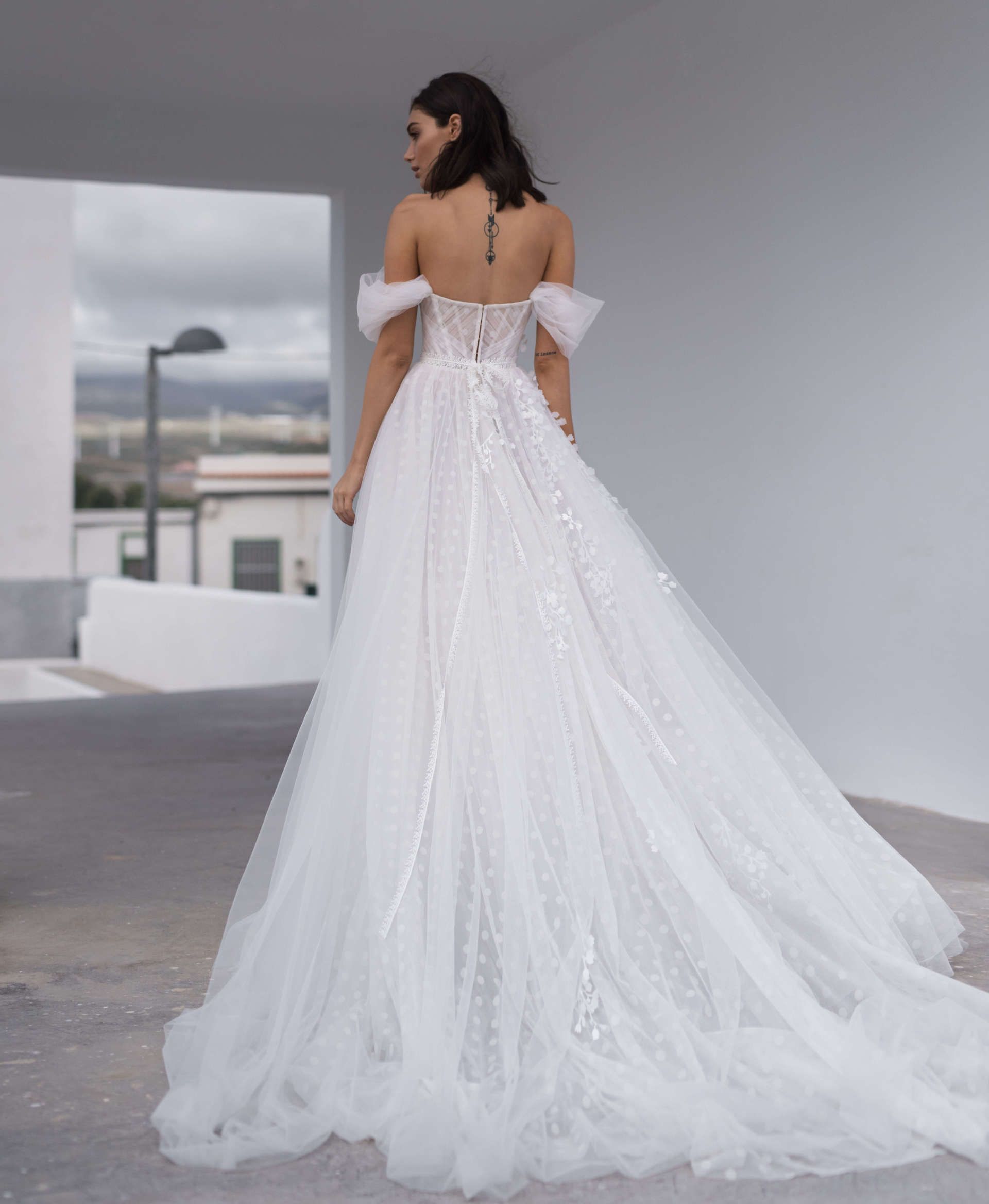 Der Rücken einer Frau in einem weißen Hochzeitskleid.