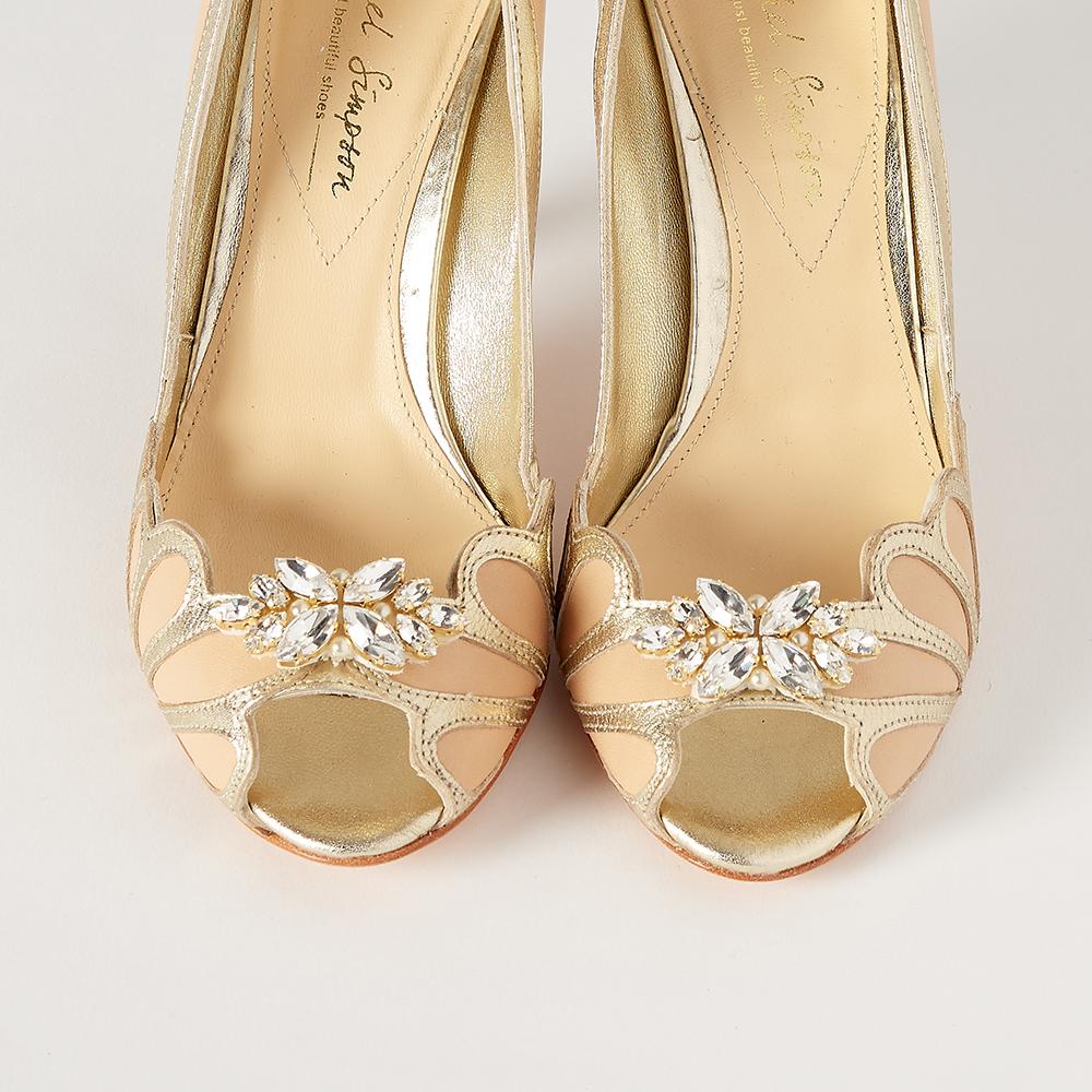 Ein Paar goldene Schuhe mit Strasssteinen darauf