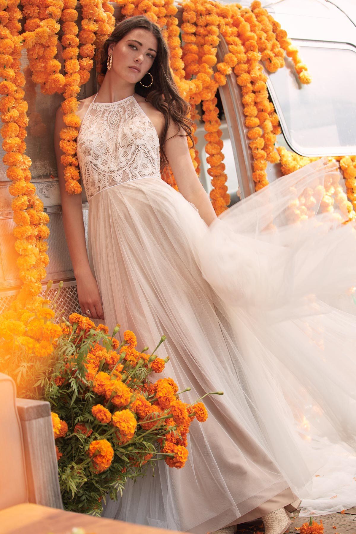 Eine Frau in einem Brautkleid steht vor Blumen.