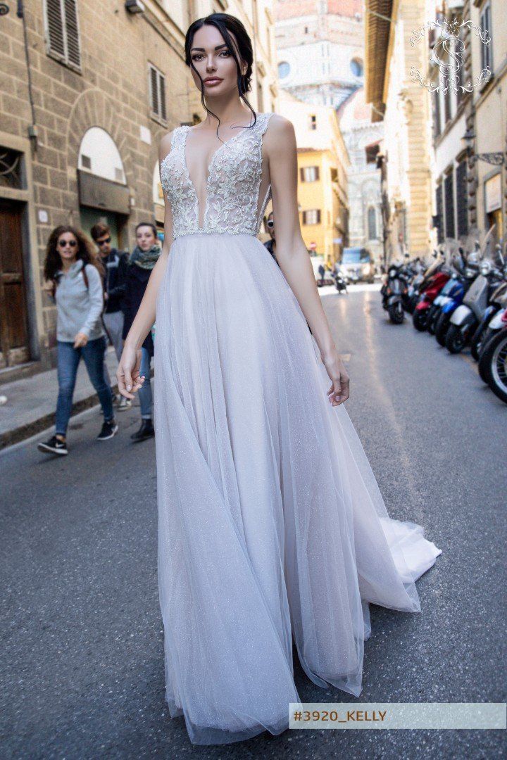 Eine Frau in einem Brautkleid geht eine Stadtstraße entlang.