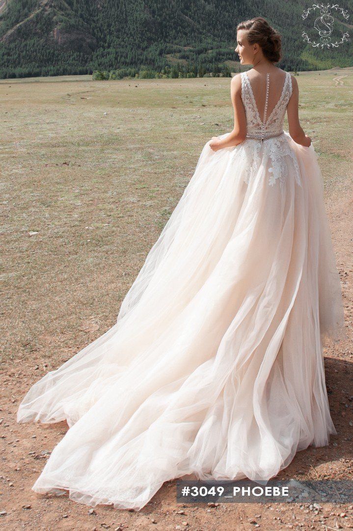 Eine Frau in einem Brautkleid steht auf einem Feld.