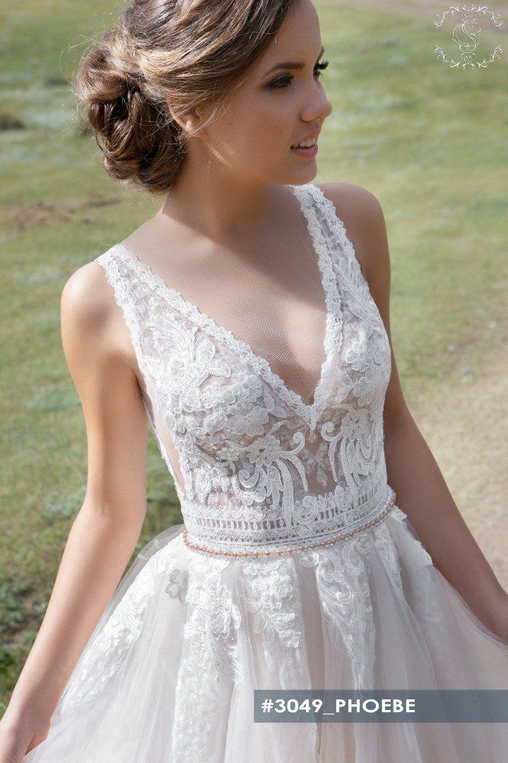 Eine Frau in einem Brautkleid steht auf einem Feld.