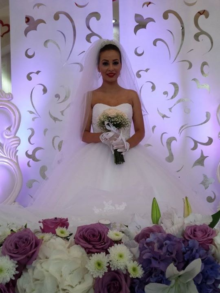 Eine Braut in einem weißen Kleid hält einen Blumenstrauß