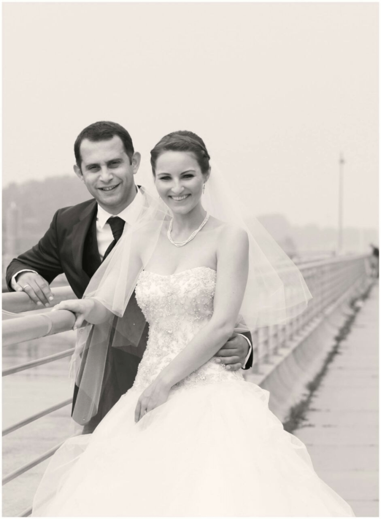 Ein Schwarzweißfoto von Braut und Bräutigam auf einer Brücke