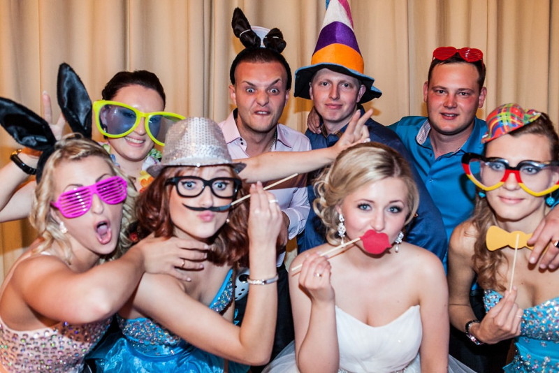 Eine Gruppe von Menschen posiert in einer Fotokabine für ein Foto.