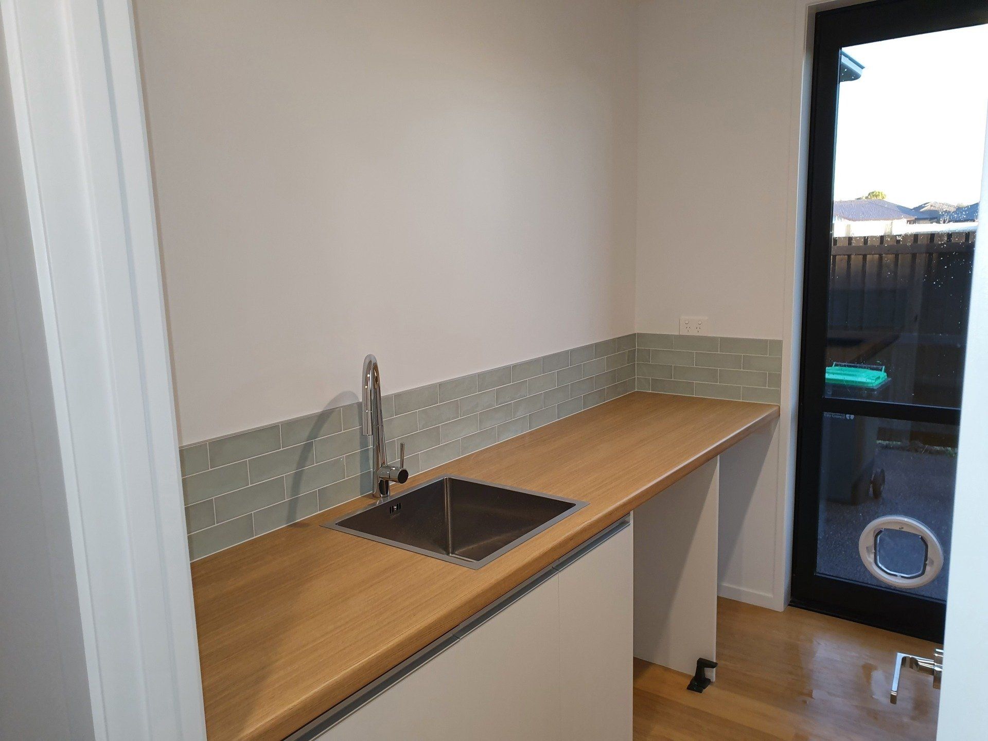 A kitchen with a sink and a wooden counter top.