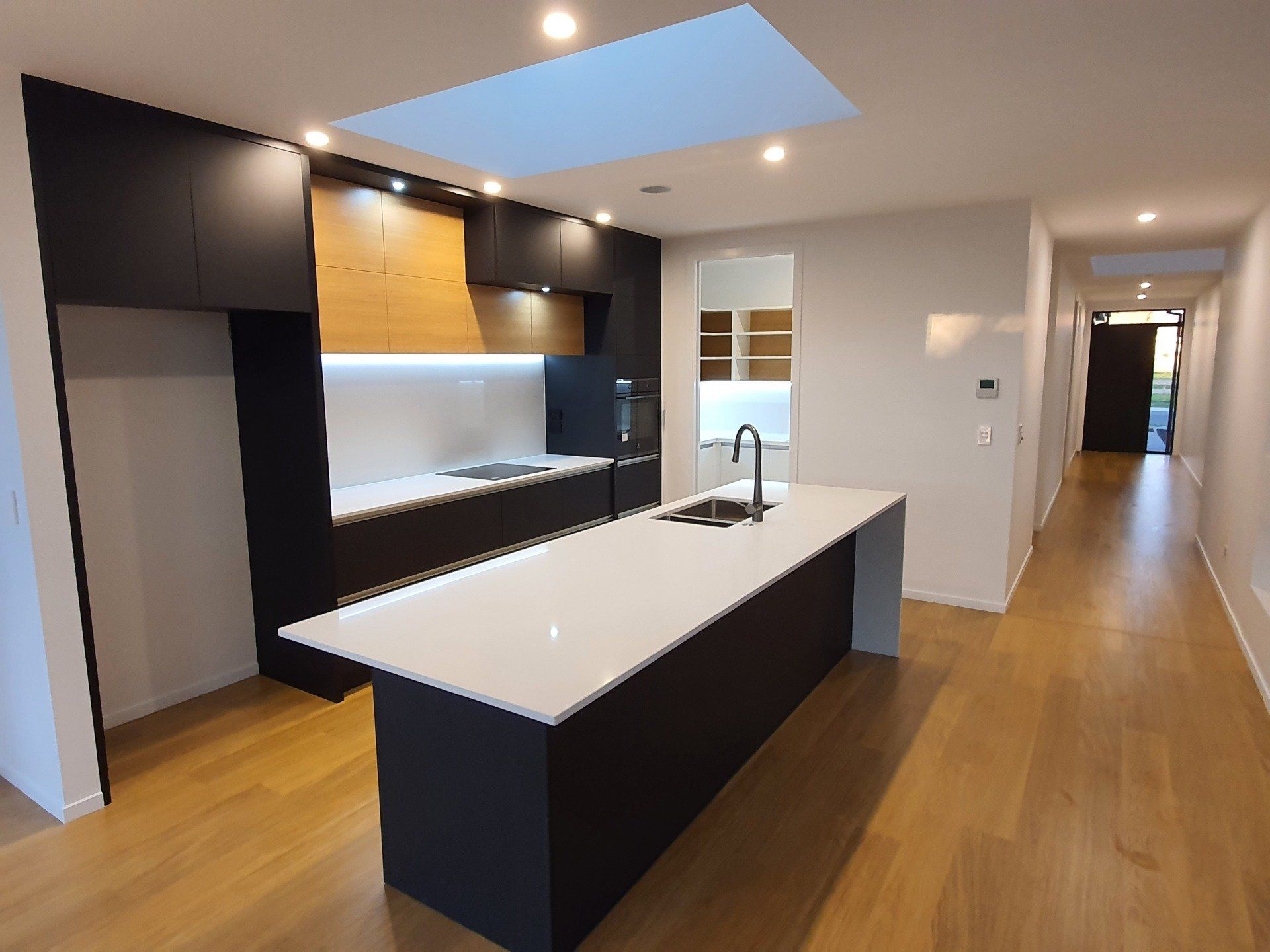 An empty kitchen with a large island in the middle