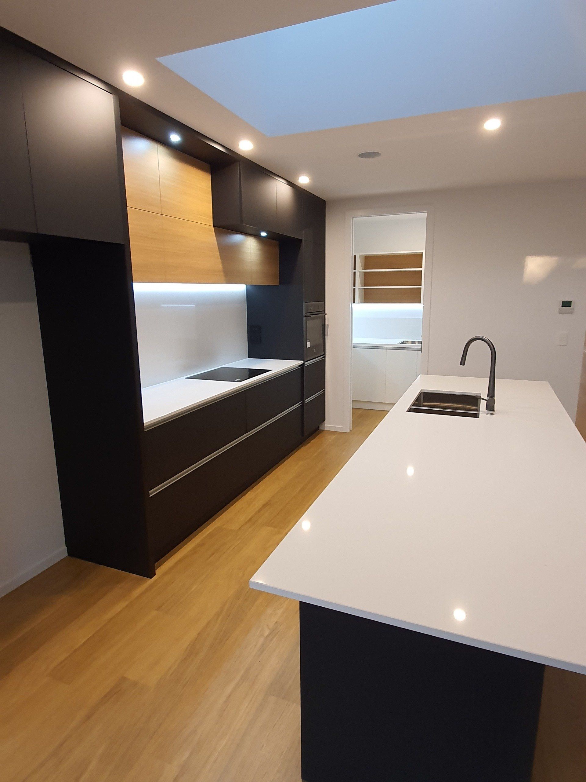 A kitchen with black cabinets and white counter tops
