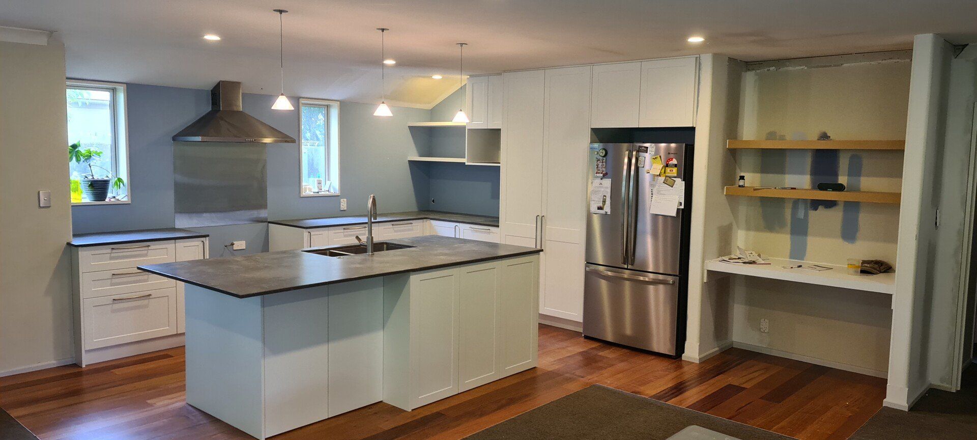 A kitchen with stainless steel appliances and a large island in the middle of the room.