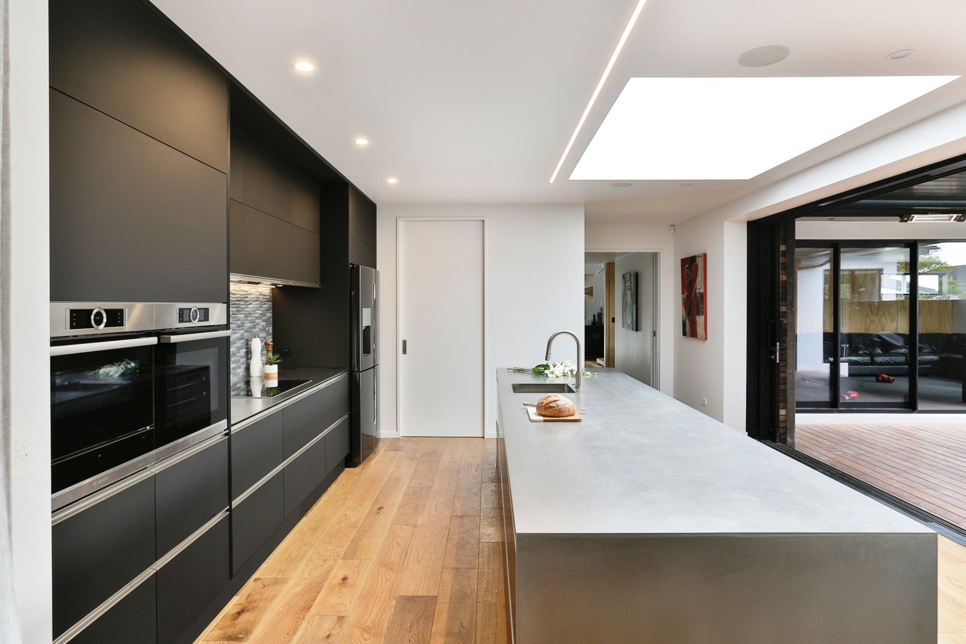 A kitchen with black cabinets and stainless steel appliances