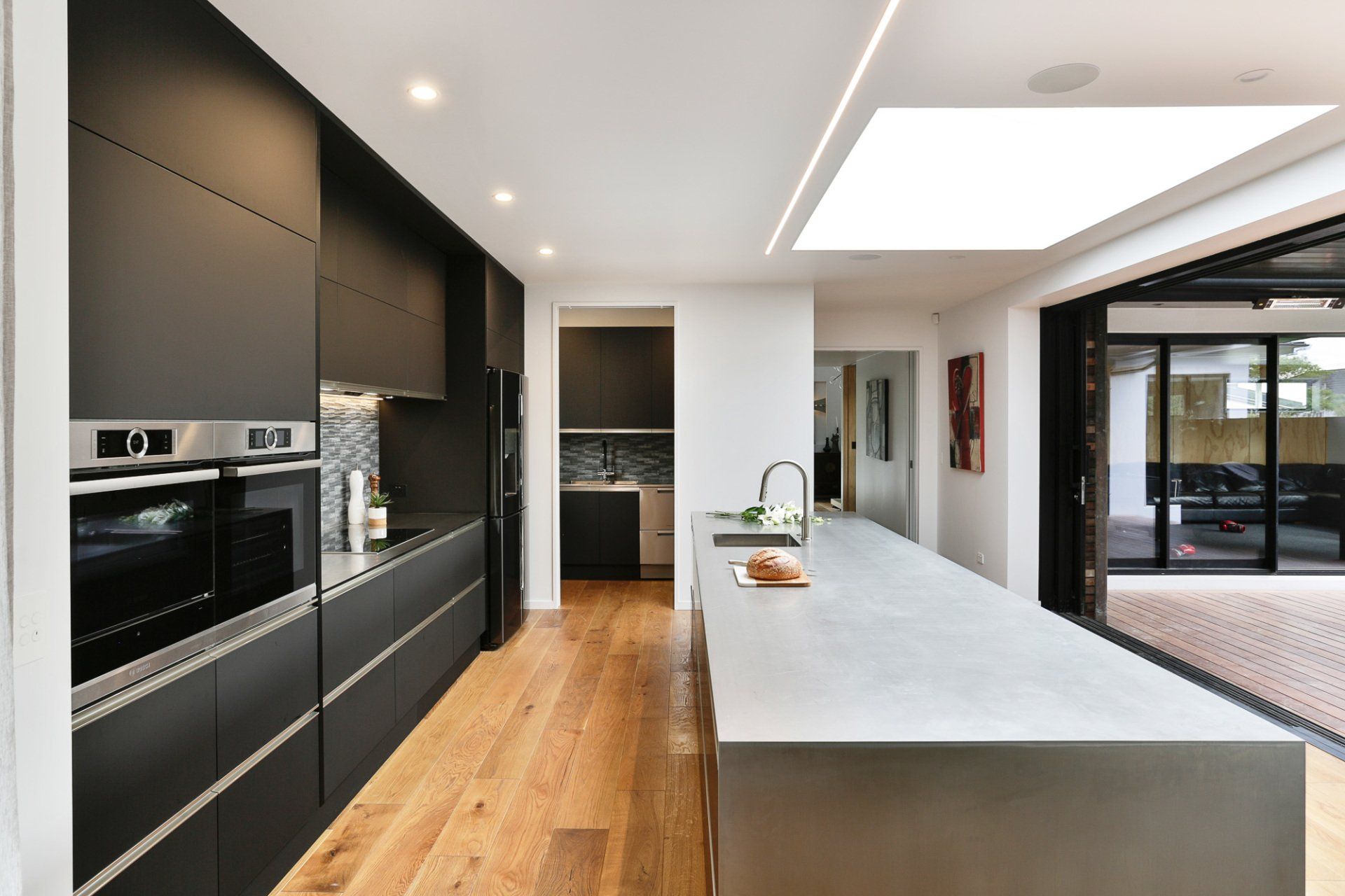 A kitchen with black cabinets and stainless steel appliances