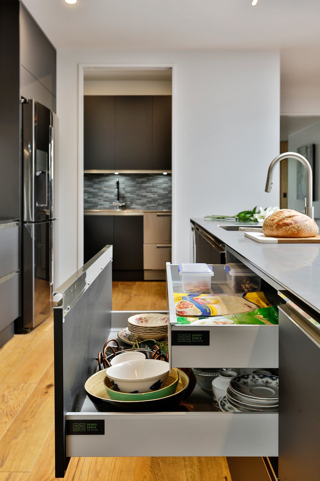 A kitchen with a lot of drawers open and a sink.