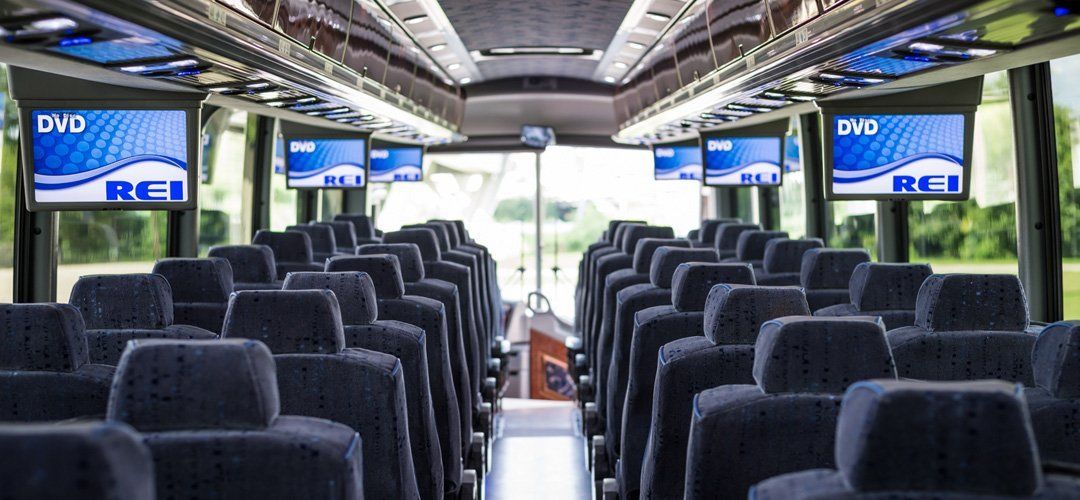 the inside of a coach bus with a dvd player on the ceiling .