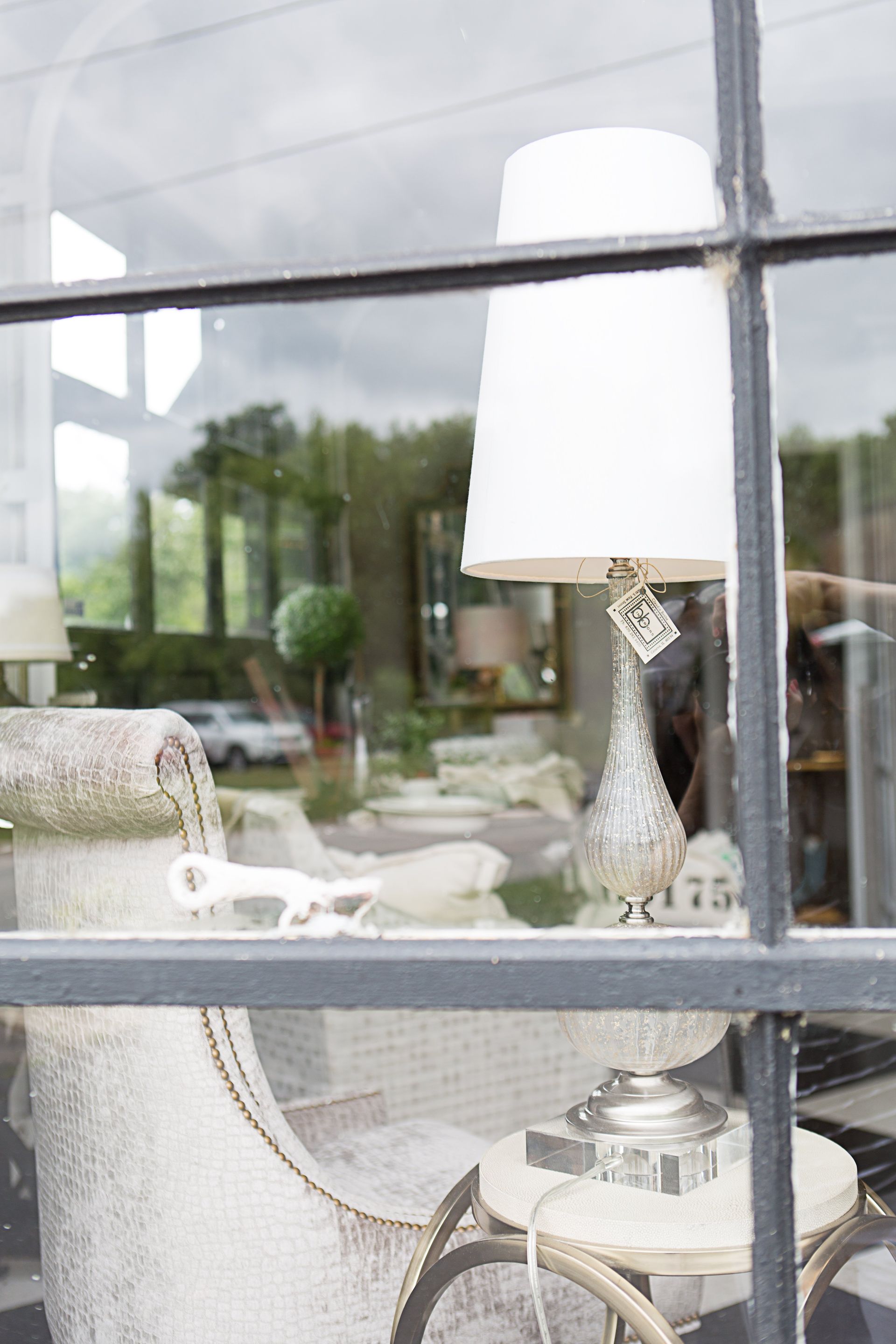 A lamp is sitting on a table in front of a window.