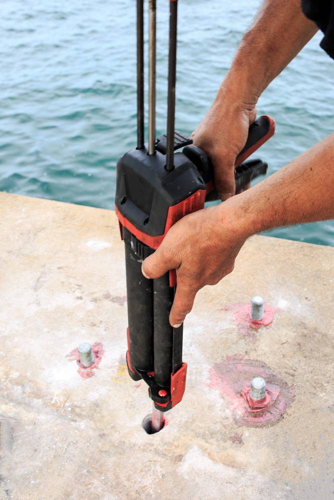 man drilling holes to install nuts and screws