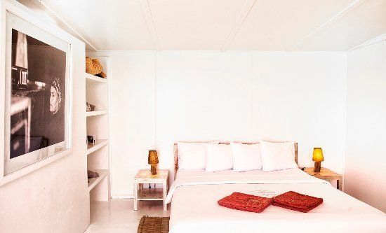 Une chambre avec un lit, deux tables de nuit et un tableau sur le mur.