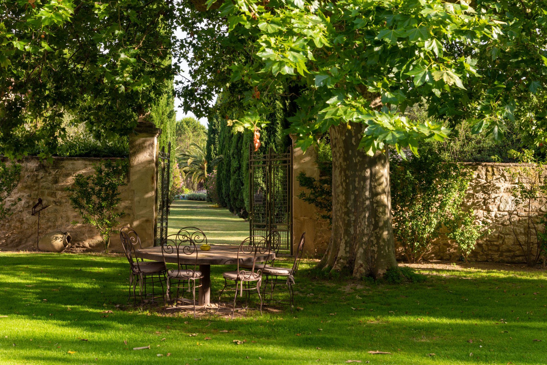 Une table et des chaises se trouvent au milieu d'un champ vert luxuriant.