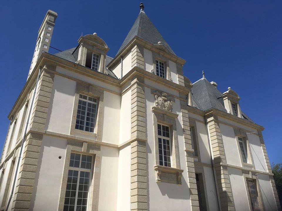Un grand bâtiment blanc avec un ciel bleu en arrière-plan