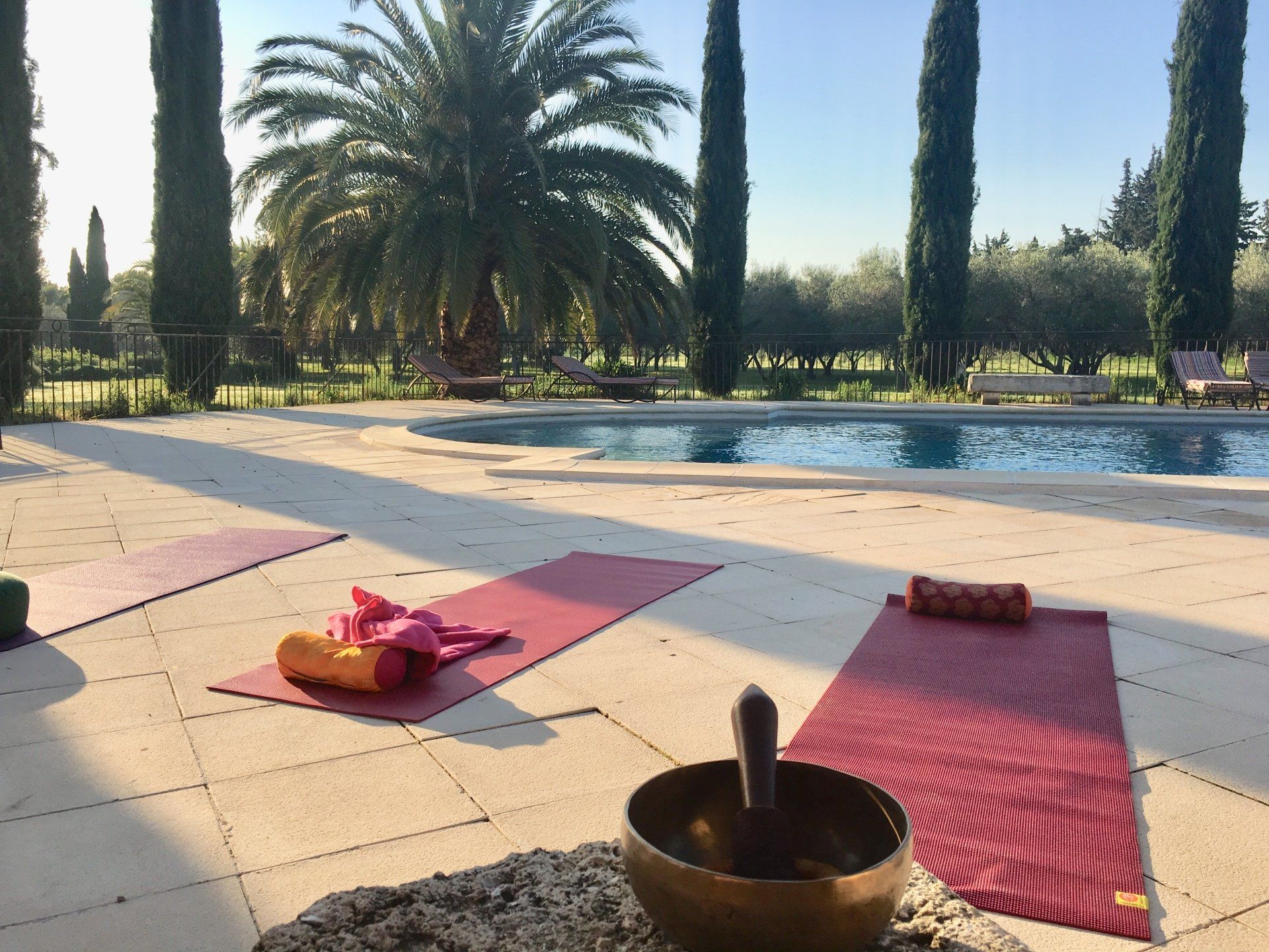 Une piscine avec des tapis de yoga et un bol chantant