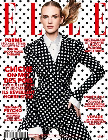 Une femme est sur la couverture d'un magazine portant un costume à pois noir et blanc.