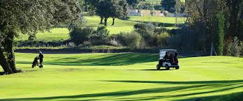 Une voiturette de golf roule sur un parcours de golf.