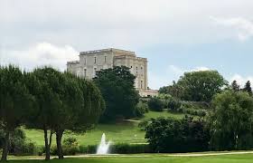 Il y a un château en arrière-plan et une fontaine au premier plan.