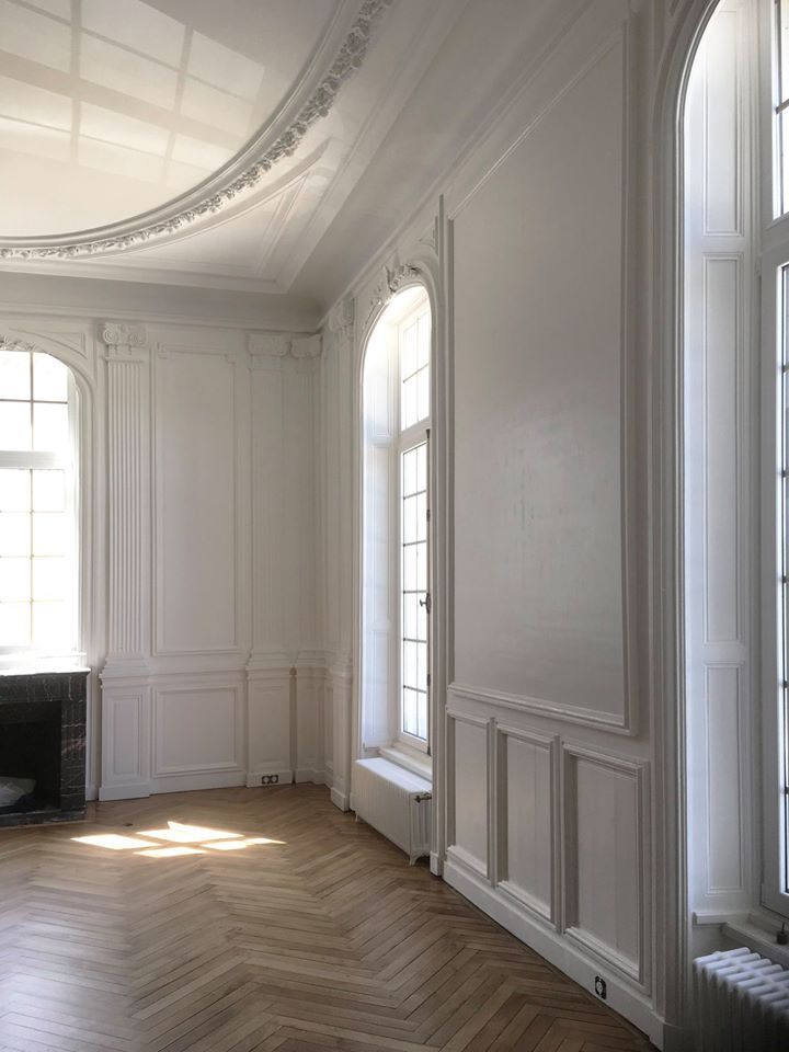 Une pièce vide avec des murs blancs et un plancher en bois.
