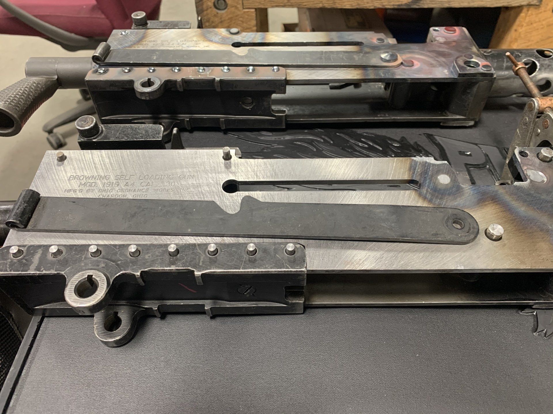Metal machine components with welded parts, on a work surface.