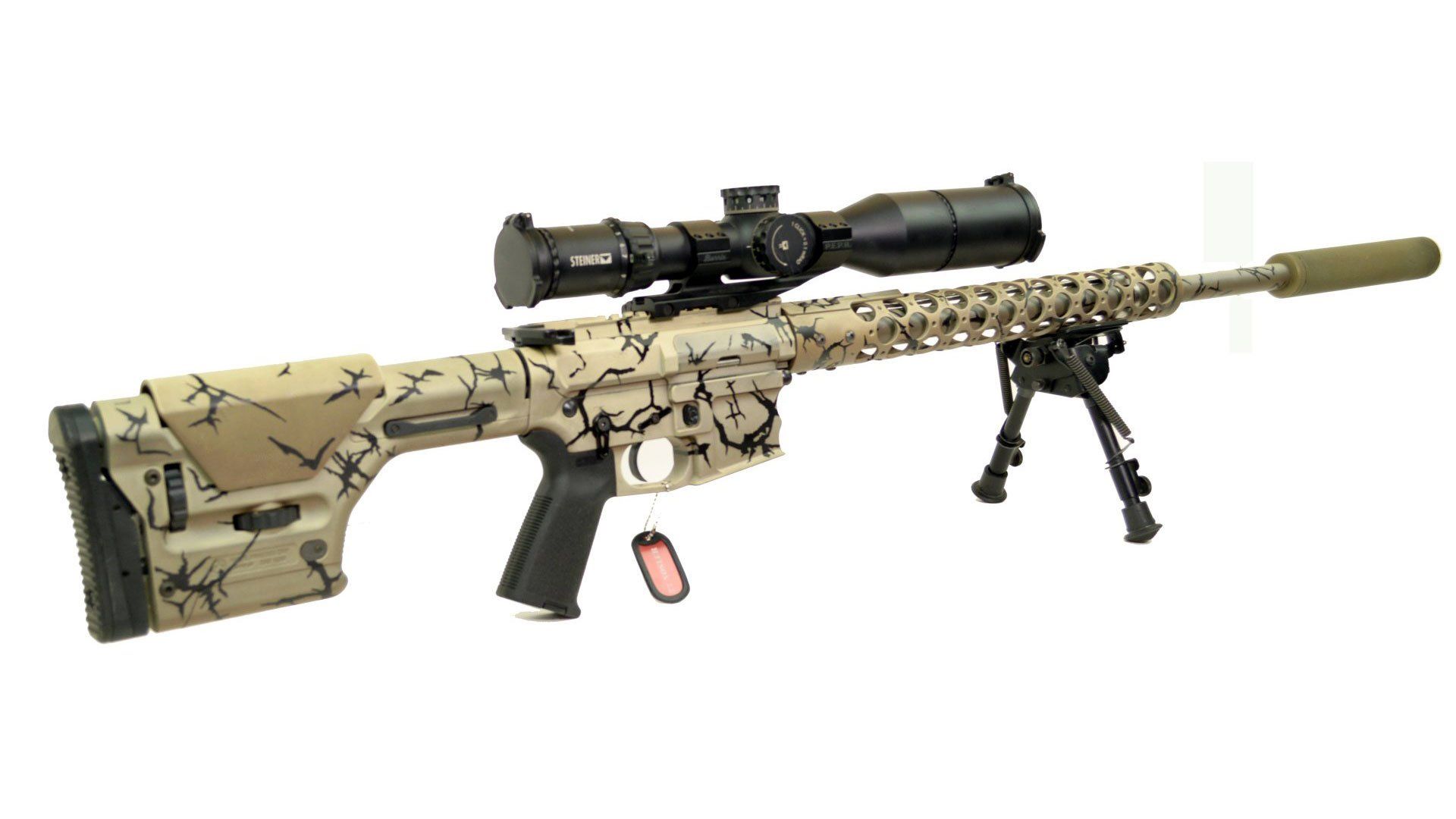 Tan and black camouflage sniper rifle with scope and bipod.