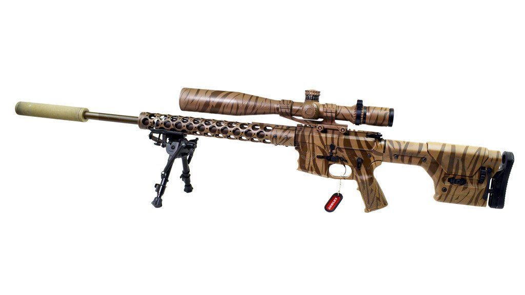 Sniper rifle with camouflage pattern, mounted scope, bipod, and silencer.