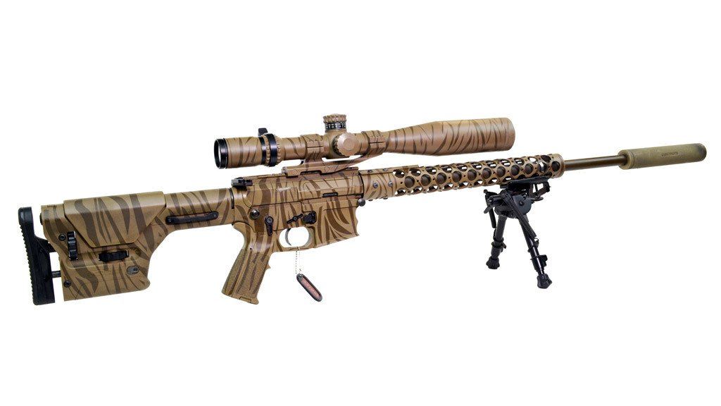 Camouflaged sniper rifle with scope, bipod, and suppressor against a white background.