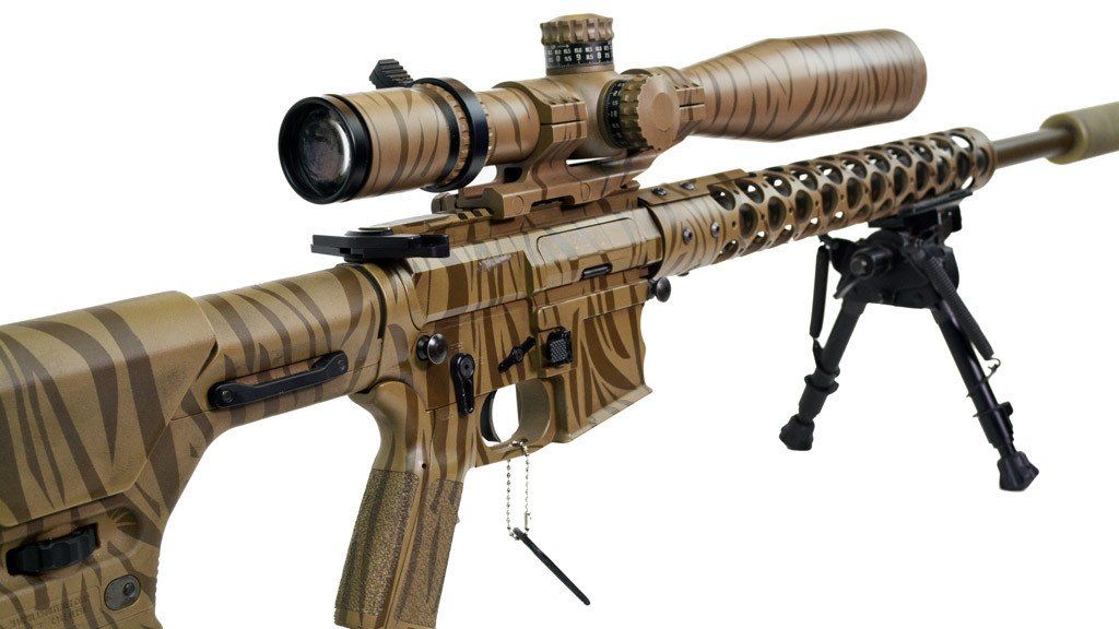 Tan camouflage rifle with scope and bipod.