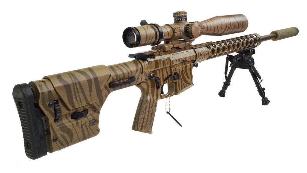Camouflage sniper rifle with scope and bipod.