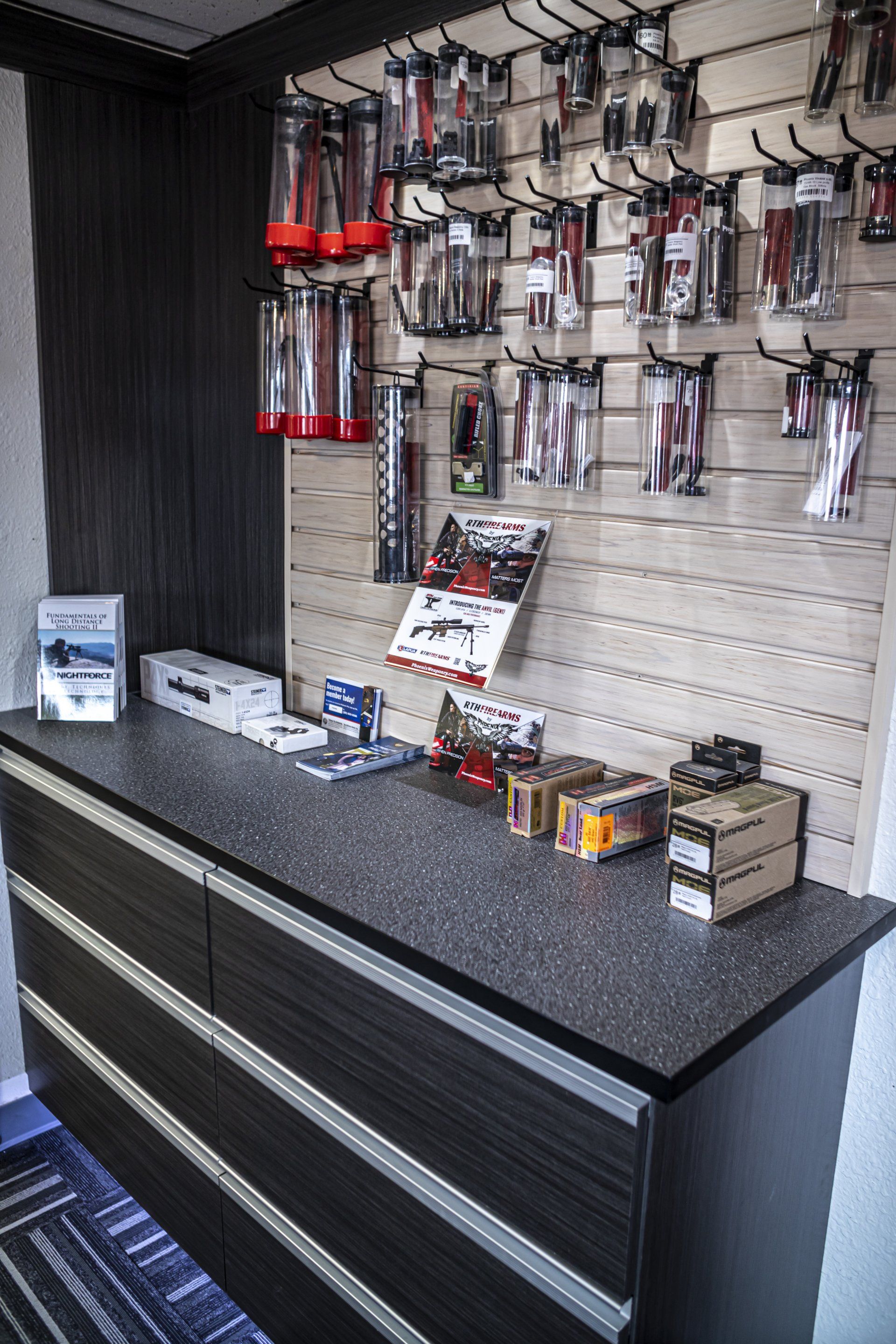 Display of tools and accessories on a countertop and slatwall. Many items are packaged in plastic.