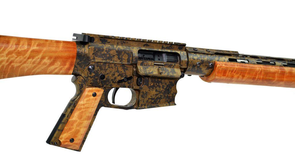 AR-15-style rifle with wood grain components and a camouflage-patterned receiver.