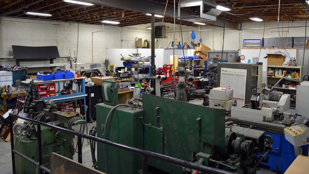 Workshop interior filled with machinery and tools. A cluttered space with various equipment.