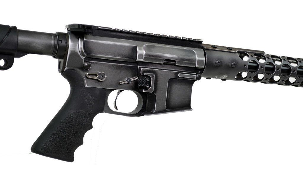 Black and silver rifle, with a textured handgrip and hollow barrel, set against a white background.