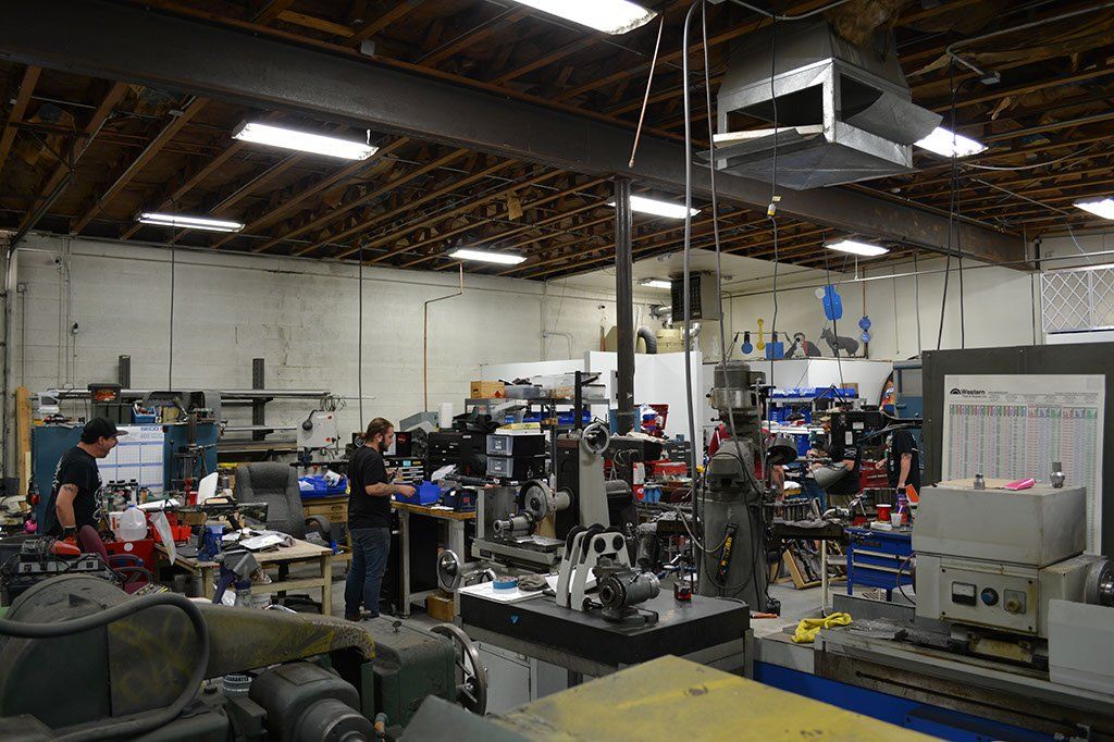 Workshop interior with people working on machinery and equipment.