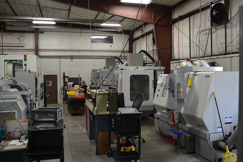 A machining workshop with several industrial machines, bright lighting, and an open layout.