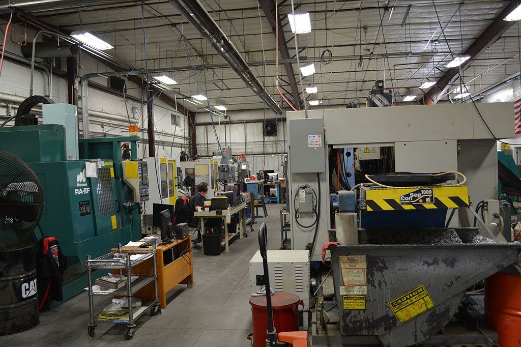 Inside a machine shop with various industrial machinery and tools.