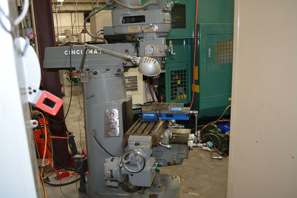 Gray milling machine in a workshop setting.