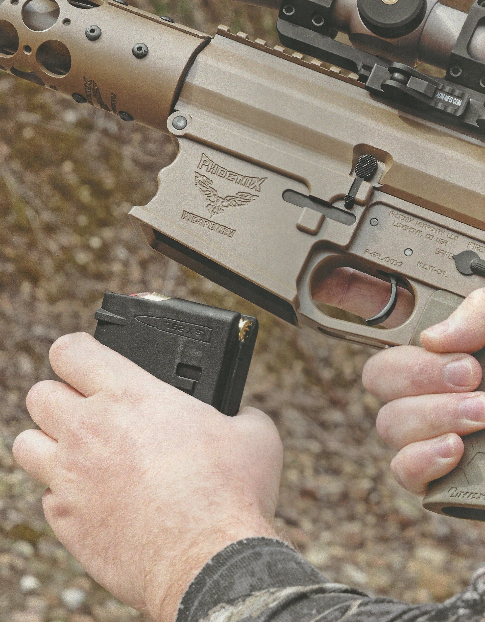 Person's hands reloading a rifle with a black magazine. The rifle is tan. Outdoor setting.