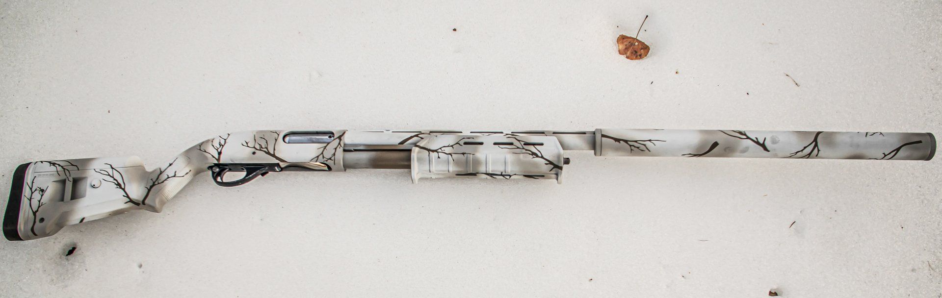 Shotgun with white and gray camouflage pattern.