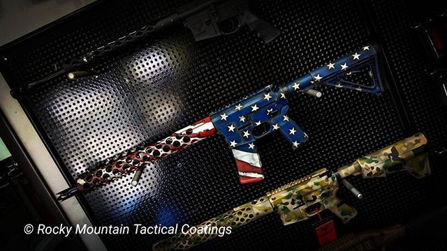 Firearms on display with custom American flag and camouflage patterns.