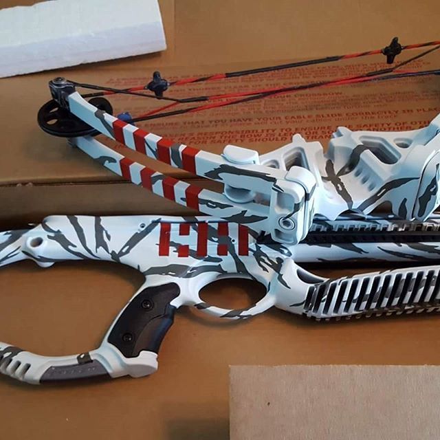 White and gray crossbow with red accents and the number