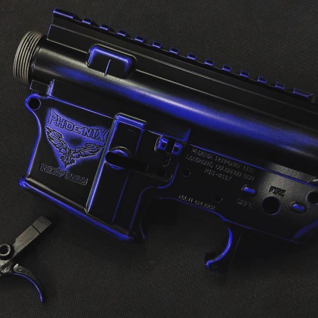 Black firearm receiver with blue accents and Phoenix logo.