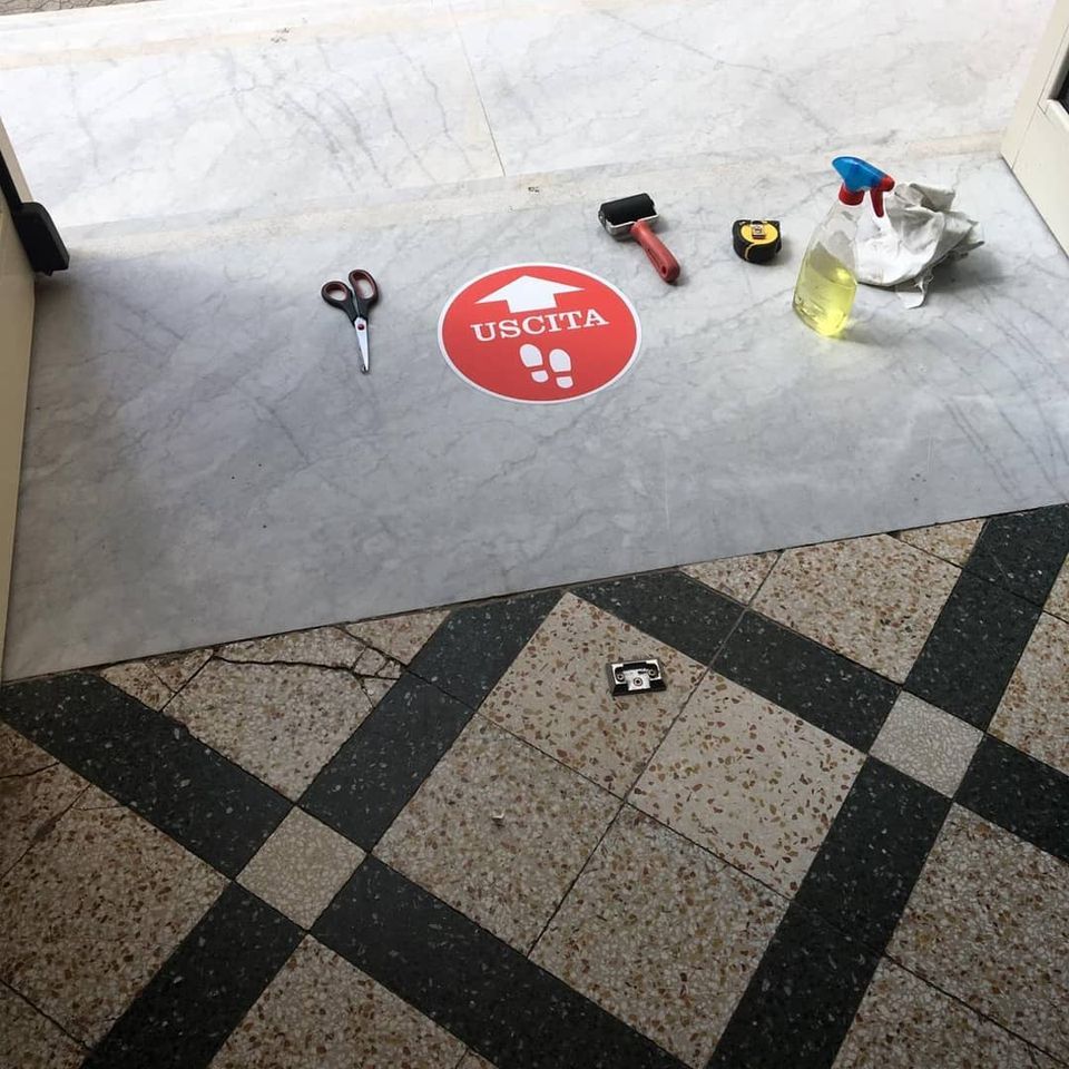 Forbici, martello, metro a nastro, flacone spray e un panno su un pavimento con un segno rosso